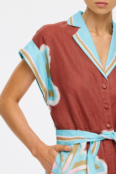 Close-up studio shot focusing on the contrast notched lapel collar, button-down front, and cap sleeves of the printed playsuit.