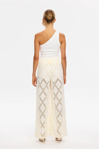 Back view of a model wearing the KIVARI Izzy Pant in Cream showing the high-waisted relaxed fit and diamond crochet inserts.