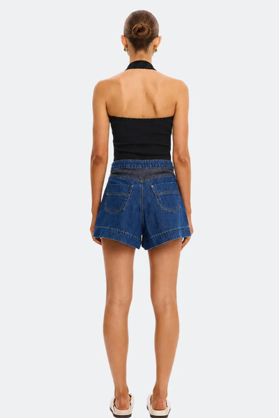 Back view of a model wearing the backless Kivari Rhea Halter Top in Black, showcasing the hand-crocheted trim around the back band and halter neck strap.