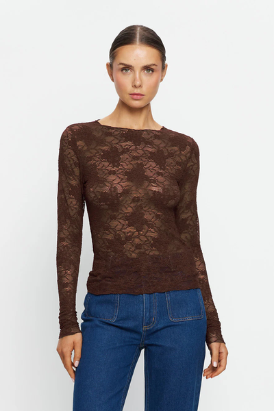 A mid-shot studio portrait of the model from the waist up, facing front against a white background. This framing provides a clear view of the semi-sheer transparency level of the chocolate brown floral lace, the high neckline construction with babylock edging, and the close, body-skimming fit across the chest and shoulders.