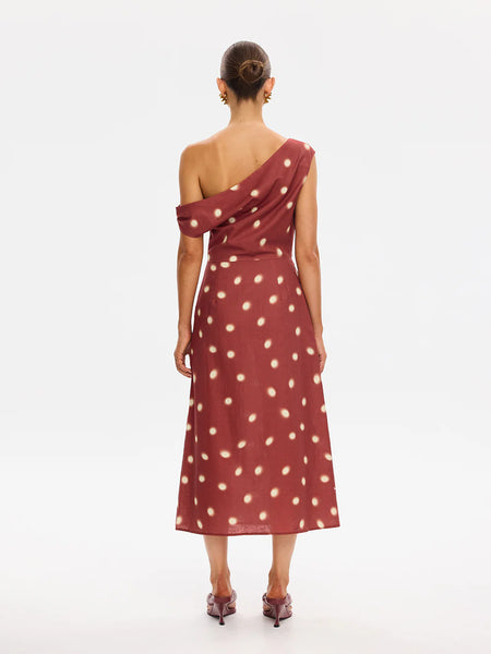 A full-length studio back view of a model wearing the Saro Midi Dress, detailing the clean asymmetric back line, the sleek fit over the hips, and the subtle, elegant drape of the fabric.
