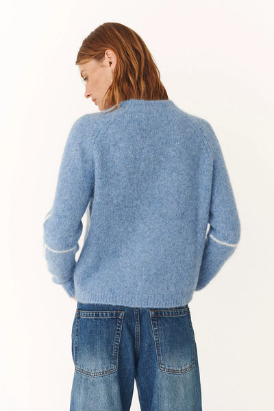 A soft and airy alpaca-blend sweater in a serene sky blue, designed for effortless layering and a cozy, modern winter aesthetic.