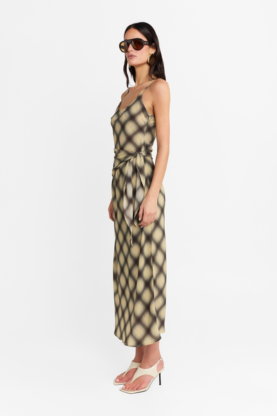 Full-length side profile view of a model wearing the check maxi dress with a wrap tie waist, highlighting the silhouette and lightweight drape.