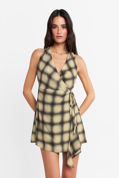 Close-up front view of a model wearing the bold check mini dress with a V-neckline, halter straps, and a side tie.