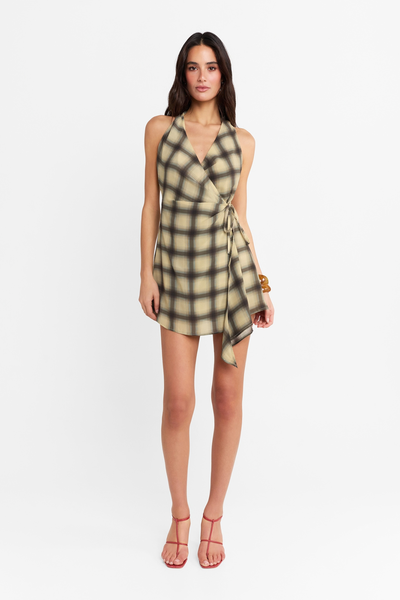 Full-length studio front view of a model wearing the Eloise Mini Dress in Check, styled with a halter neckline, wrap tie, and red heels.