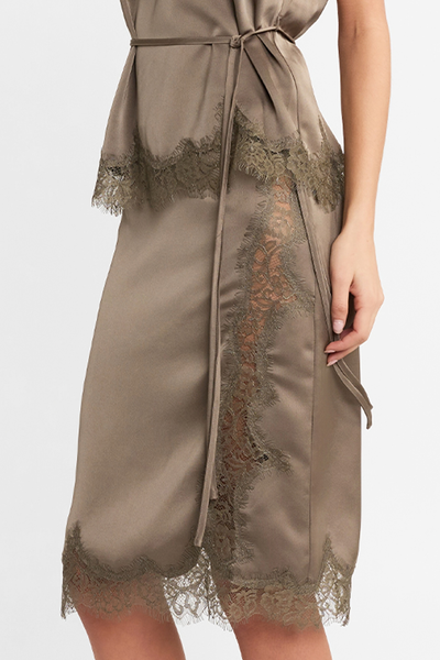 Close-up side profile view of a model wearing the Velune Skirt, highlighting the side lace panel, scalloped lace hem, and the thin tie belt from the matching top.