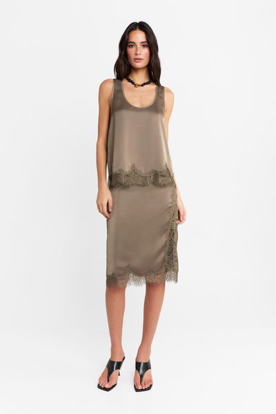 Full-length front studio view of a model wearing the complete two-piece Velune set in thyme satin featuring a scoop-neck tank top and lace-trimmed midi skirt, styled with a black statement necklace and black heels.