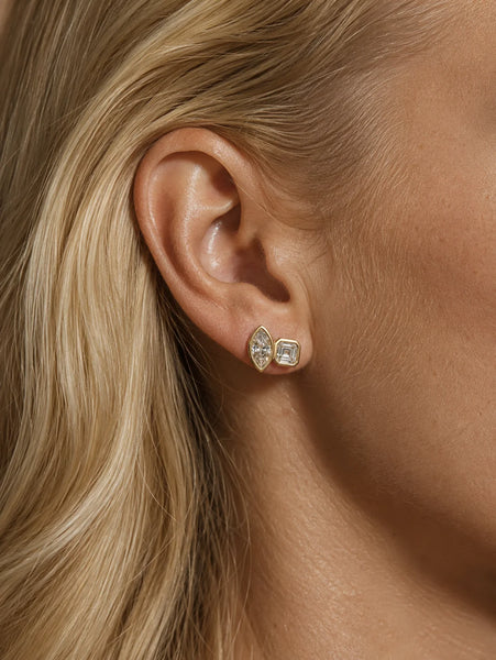 Close-up profile of a model's ear wearing the gold Marguerite stud, highlighting its scale and double-cut silhouette.