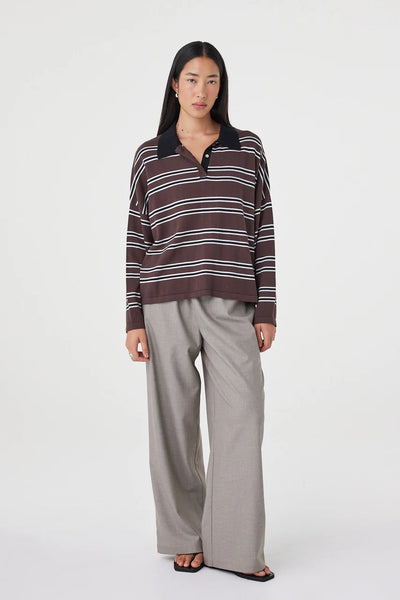 A full-length studio shot with the model positioned in a subtle side-facing turn, emphasizing the casual drape, comfortable oversized proportions, and clean-finished ribbed cuffs.