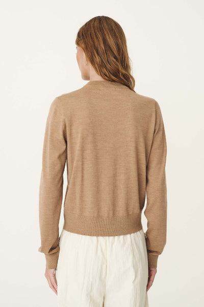 Rear view studio shot of a model wearing the ROWIE Maeve Merino Spring Cardigan in Fawn Marle, showcasing the fine superfine merino wool knit texture, ribbed hem, and set-in long sleeves.
