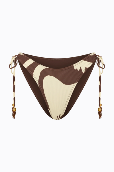 Flat product shot of the Ochre Lane string bottom in the Ibisco abstract floral print against a clean white background, showing the adjustable side ties with bead details.
