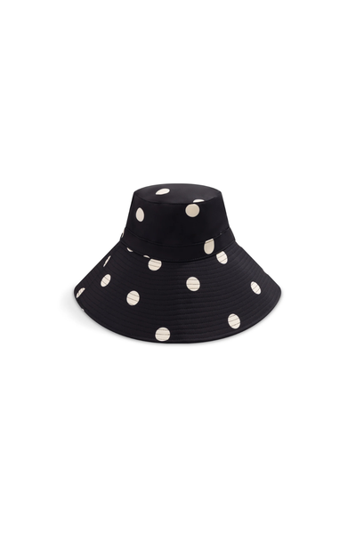 A macro product shot focusing on the crown's seam panels, detailing the uniform alignment of the noir dot pattern and the subtle structural stitch definition for everyday wear.