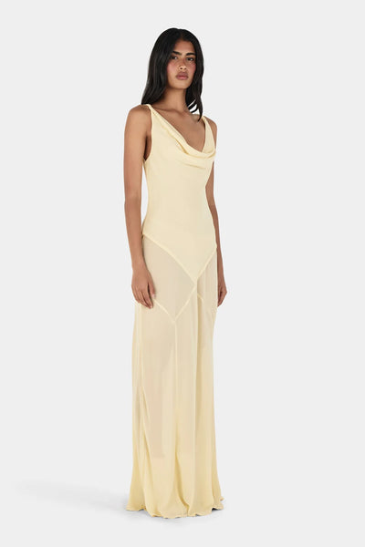 Studio three-quarter front view of a model wearing a butter yellow cowl neck maxi dress with twisted shoulder straps