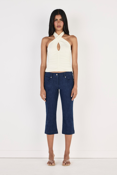 Shop the OWNLEY Yoita Top in Ivory online. Features a crossover halter neckline, center front keyhole cut-out, and ruched side detailing. Free shipping options available.