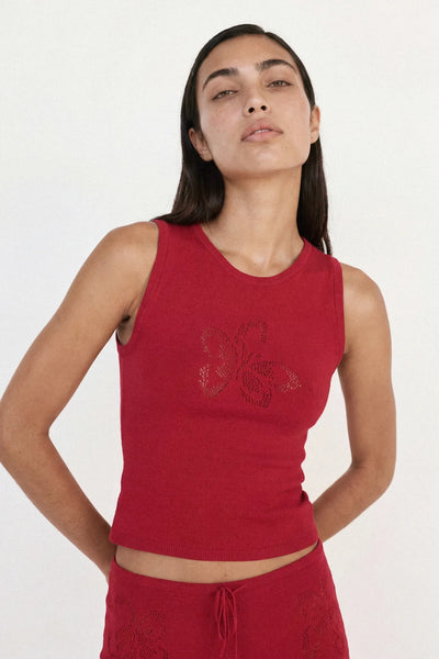 Close-up studio portrait of model wearing the Ownley Inka Top in Lipstick, featuring ribbed neck trim and subtle pointelle floral knit detail at the center front.