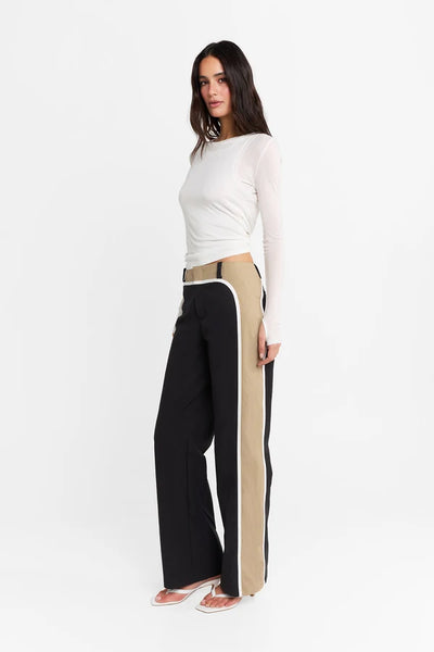 Studio side-profile view of a model wearing the fitted long-sleeve top, highlighting the clean body-contouring lines and smooth stretch fabric.