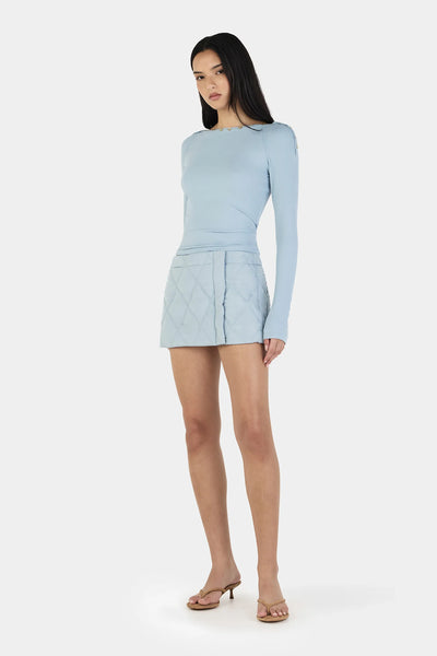 A side profile studio shot illustrating the slim, contoured drape of the bodice and the elongated 73.5cm sleeves gathering naturally and comfortably at the wrists.