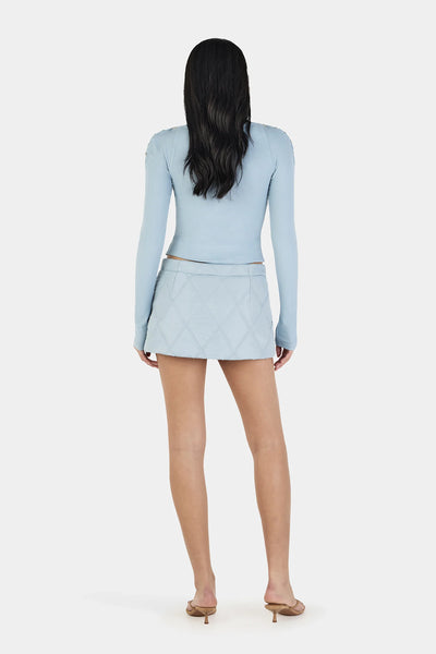 A full back view of the ice blue long sleeve top on a model, highlighting the uniform ribbed stitch texture and the clean, secure fit across the upper back and shoulder blades.