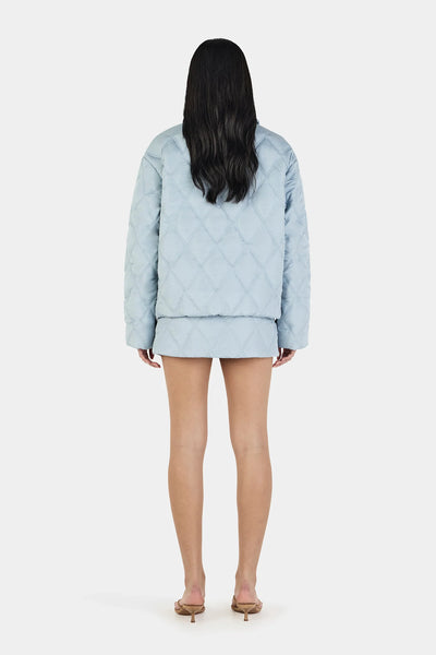 A full back view of the Quinton Jacket on a model, showcasing the clean, horizontal and diagonal quilted line panels across the shoulders and down to the 63cm hemline.