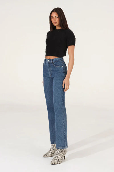 A side profile studio product image of the black cropped knit short-sleeve top, emphasizing the ultra-soft, cloud-like tactile texture of the fabric blend and the structured fit along the waist.
