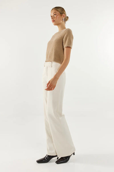 A full-length side profile studio view of a model wearing the Ruby knit top, highlighting its cropped hemline and the plush, cloud-like texture of the fabric blend.