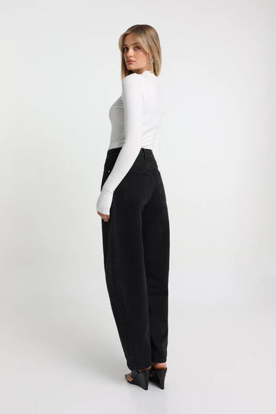 A three-quarter studio product image of the white stretch fabrication long-sleeve top, demonstrating its versatile capsule wardrobe styling from an angled perspective.