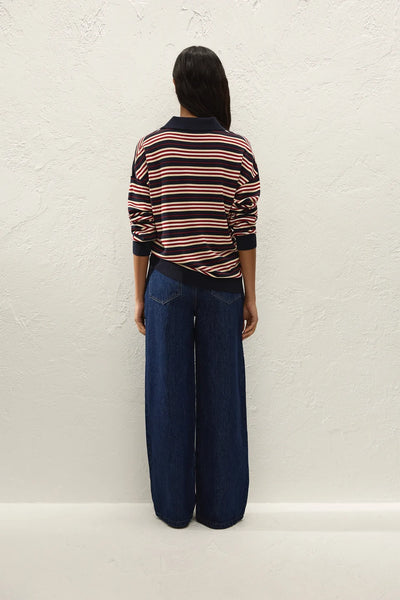 Full-length back view of model wearing the Faithfull The Brand Harlow Oversized Polo in Cila Stripe Navy paired with wide-leg dark wash denim jeans.