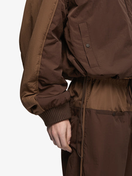 Close-up studio detail shot showcasing the elasticated ribbed cuffs, contrast nylon piping, and snap-button welt pockets on the Bec + Bridge Laney Jacket in Choc/Coffee.