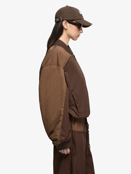 Three-quarter side profile view highlighting the contrast panelled sleeves and bomber silhouette of the Bec + Bridge Laney Jacket in Choc/Coffee.