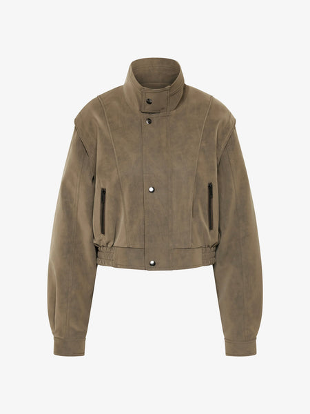 A full-length front studio shot of a model wearing the Bec + Bridge Zoli Bomber in Olive, showcasing its classic bomber silhouette, structural shoulder panel detailing, and rich khaki-olive matte finish.