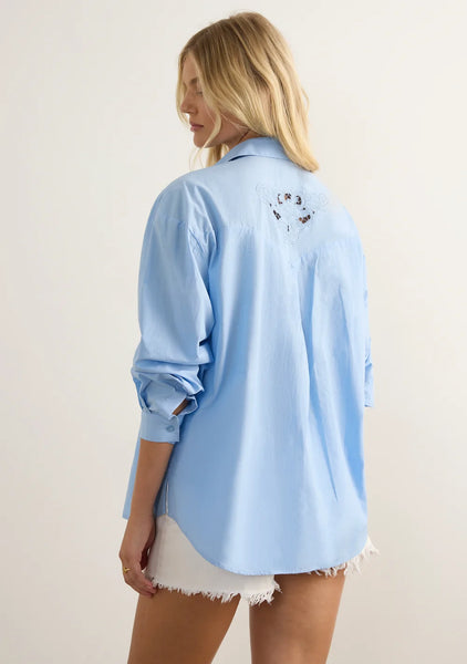 Back view of the Auguste the Label Holden Embroidered Shirt in Business Blue, highlighting the Western-style back yoke and delicate lace cutout detailing on the upper back.