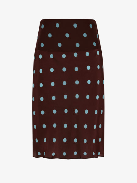 A clear product-only photograph isolating the Mathilde Midi Skirt against a plain background. The shot highlights the brown fabric with light blue polka dots, the structured wide waistband, and the fluid drape of the bias-cut silhouette.