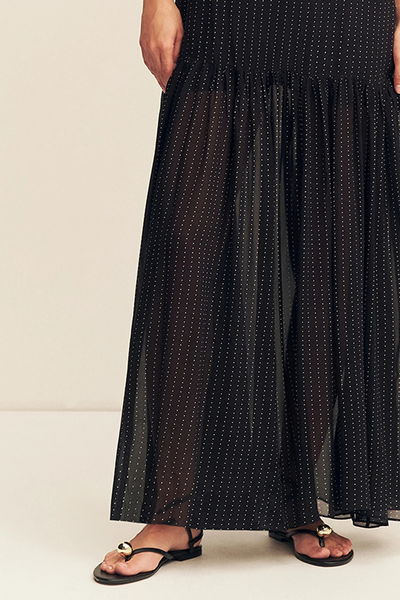 Close-up detail shot of the lower skirt on the Shona Joy Irving Polka Dot Maxi Dress, showcasing the dropped gathered waist, semi-sheer georgette fabric, and black flat sandals with gold hardware.