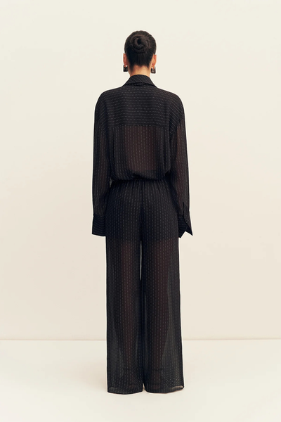 Direct back view of a model wearing the Shona Joy Irving Polka Dot Sheer Pant in Black Polka Stripe with the matching top tucked into the elasticated waistband.