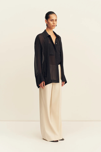 Three-quarter front view showing the sheer georgette drape and collared neckline of the Shona Joy Irving Polka Dot Sheer Shirt in Black Polka Stripe.