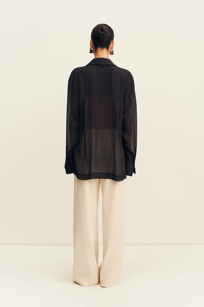 Full back view of a model wearing the Shona Joy Irving Polka Dot Sheer Shirt in Black Polka Stripe highlighting the sheer back panel and horizontal shoulder yoke.