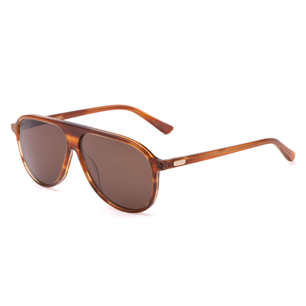 Three-quarter view portrait of a model wearing the Sito Shades Bobbi in Tangelo translucent orange aviator sunglasses with dark brown lenses and a black scoop-neck top.