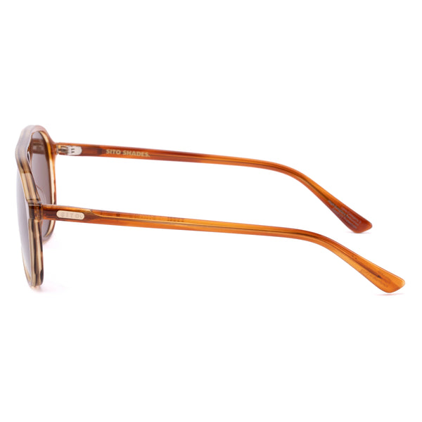 Side profile shot of the Sito Shades Bobbi in Tangelo translucent orange aviator sunglasses displaying the slim acetate temples with silver hardware detail on a plain white background.