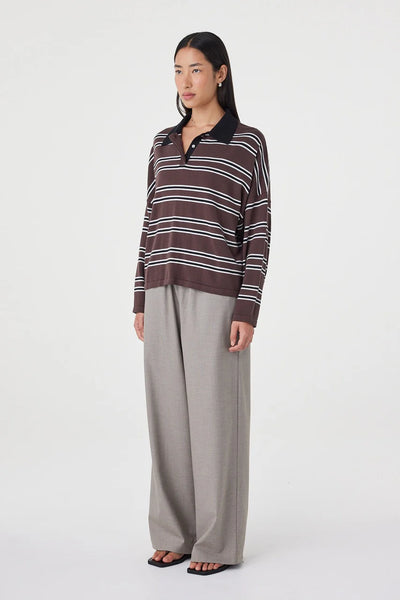 A three-quarter studio product shot with the model turned slightly to the right, illustrating the relaxed, off-body shape and easy drape of the organic cotton knit jersey.