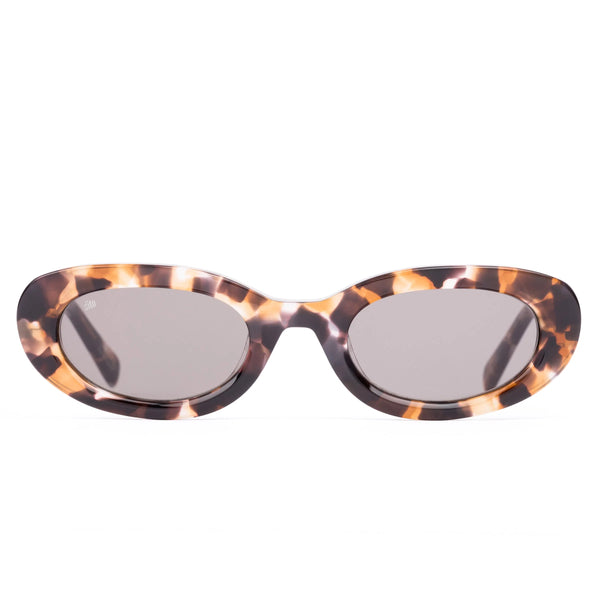 Front view studio shot of the Sito Shades Lourdes oval sunglasses in translucent pebble tort acetate with solid grey CR39 lenses on a white background.