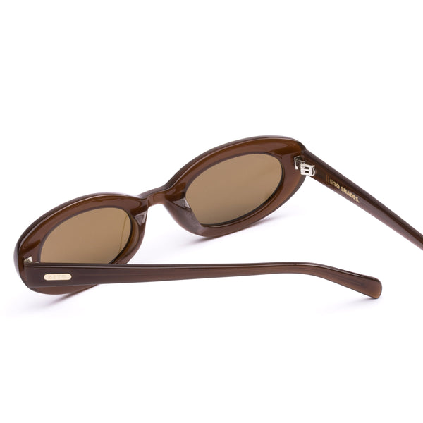 Back perspective studio view of the Sito Shades Lourdes oval sunglasses in milky coco brown acetate showing the inner temple branding and silver hinges.