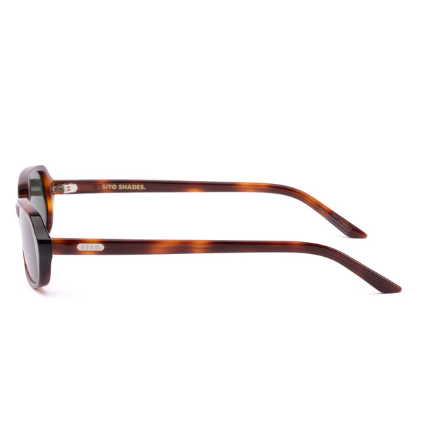 Side profile studio image of the Sito Shades Roux sunglasses in Classic Tort featuring slim acetate temples and a silver-toned brand logo plaque.