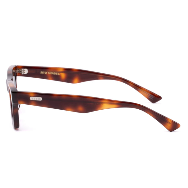 Side profile studio image of the Sito Shades Vincent sunglasses highlighting slim classic tortoiseshell acetate arms with silver logo plate detailing.