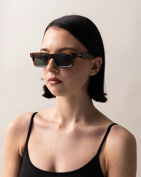 Three-quarter portrait of a dark-haired model wearing the Sito Shades Vincent rectangular sunglasses in classic tortoiseshell acetate with dark grey polarised lenses.