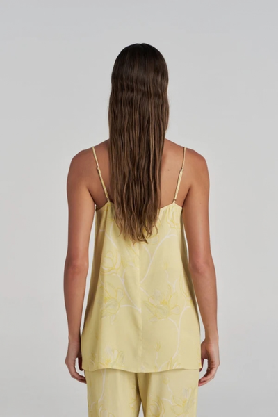 Studio rear view of a model wearing the yellow floral tunic top, showcasing the adjustable thin straps and clean drape.
