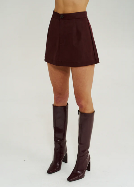 A-line mini skirt in a rich Syrah wine color, featuring a smooth woven suede texture and a flattering body-skimming silhouette.