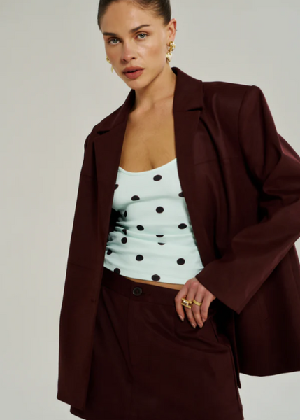 A sophisticated, minimalist A-line skirt in a deep wine-red Syrah shade, perfect for casual evenings and long lunches.