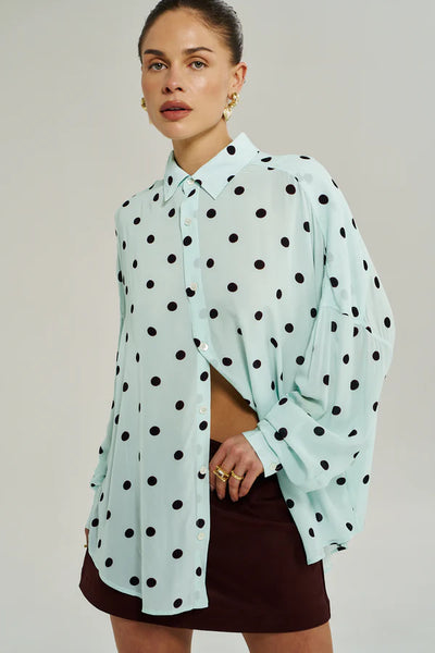 A lifestyle shot of the Dotty LS shirt worn open as a light layer, emphasizing the movement of the 90g woven viscose fabric.