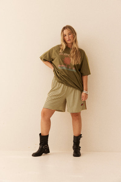 Model wearing the oversized Olive Sunset Tee, showcasing the relaxed crew neckline and natural drape of the 100% cotton fabric.
