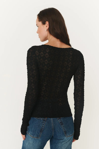 Back profile of the black lace top, highlighting the subtle stretch and the versatility of the Noir colorway for evening or off-duty layering.